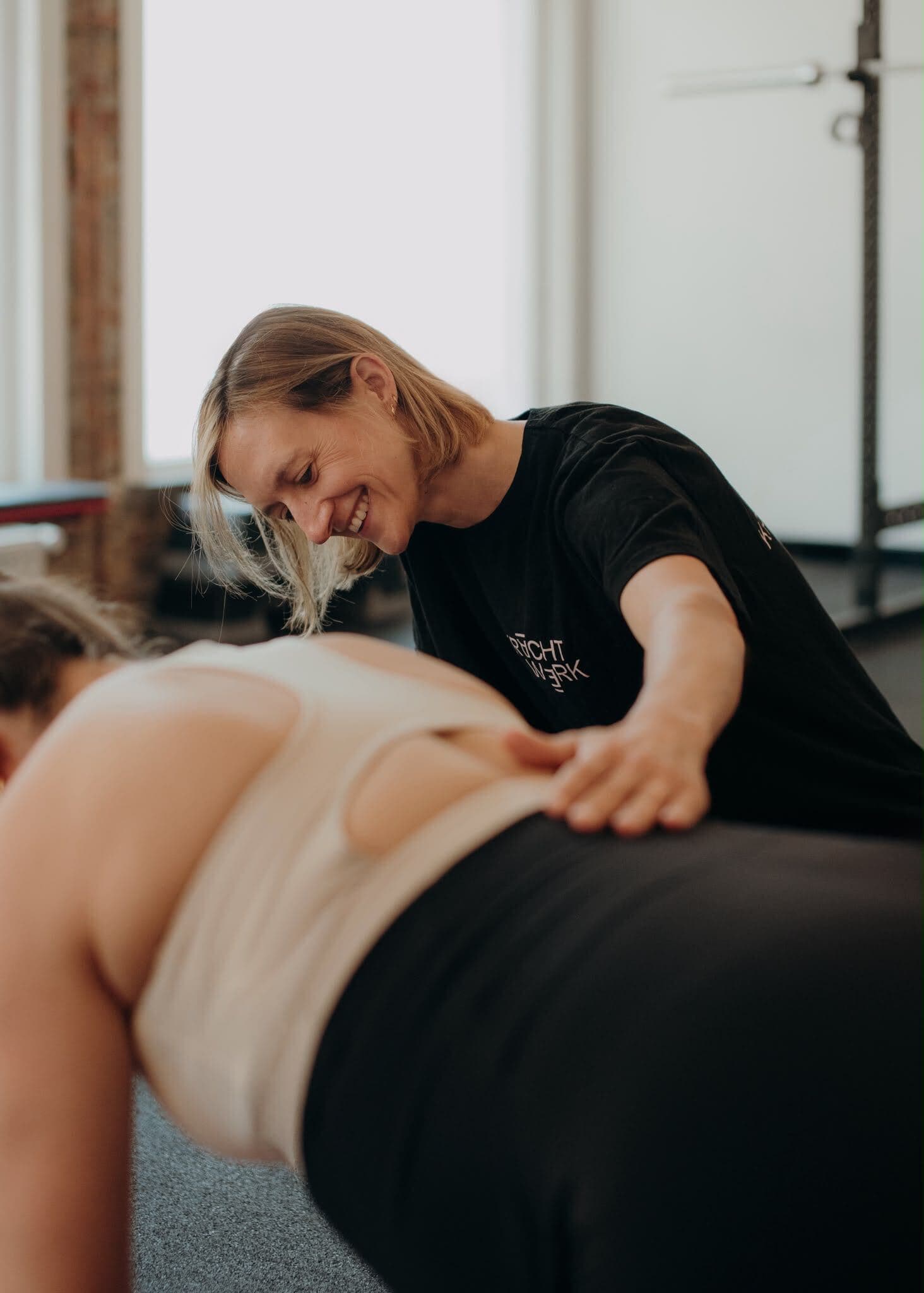 Coach geeft hands-on correctie tijdens een oefening